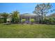 View of the screened lanai from the manicured backyard at 2311 Falcon Trace Ln, Nokomis, FL 34275