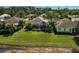 Aerial view of a home featuring a screened lanai surrounded by a well-manicured lawn and tropical landscaping at 2311 Falcon Trace Ln, Nokomis, FL 34275