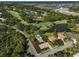 A birds-eye view of a neighborhood featuring a community pool, golf course, and lush greenery at 2311 Falcon Trace Ln, Nokomis, FL 34275
