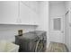 Convenient laundry room with washer, dryer, cabinetry, and utility sink at 2311 Falcon Trace Ln, Nokomis, FL 34275