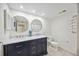 Bright bathroom features dual sinks, a navy blue vanity, marble countertop, and round mirrors at 2347 Beneva Ter # 2251, Sarasota, FL 34232