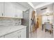 Well lit kitchen with stainless steel refrigerator, white cabinets, and a mosaic backsplash above the countertops at 2347 Beneva Ter # 2251, Sarasota, FL 34232
