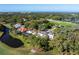 Aerial view of the property with lush landscaping, nearby golf course, and distant ocean view at 236 Saint James Park, Osprey, FL 34229