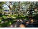 Lush backyard with brick path, mature trees, and decorative fountain creating a serene atmosphere at 236 Saint James Park, Osprey, FL 34229