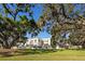 Large backyard with mature trees, sprawling green lawn, and an elegant fence at 236 Saint James Park, Osprey, FL 34229