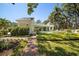 Picturesque backyard with brick path, lush lawn, trimmed hedges, and a refreshing pool area at 236 Saint James Park, Osprey, FL 34229