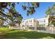 Well-manicured lawn and garden surrounding a home, complemented by a tall, decorative white fence at 236 Saint James Park, Osprey, FL 34229