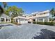 Elegant two-story home boasts a circular driveway, manicured landscaping, and attached two-car garage at 236 Saint James Park, Osprey, FL 34229
