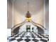 Elegant grand foyer with a sweeping staircase, black-and-white checkered floor, and a stunning chandelier at 236 Saint James Park, Osprey, FL 34229