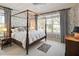 A comfortable primary bedroom with a four-poster bed, soft lighting, and scenic views at 236 Saint James Park, Osprey, FL 34229