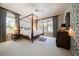 A comfortable primary bedroom with a four-poster bed, soft lighting, and scenic views at 236 Saint James Park, Osprey, FL 34229