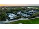Aerial view of multiple tennis courts surrounded by lush landscaping, greenery, and trees at 236 Saint James Park, Osprey, FL 34229