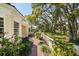Charming home featuring a brick walkway, lush landscaping, mature trees, and a well-maintained lawn at 236 Saint James Park, Osprey, FL 34229