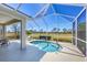 Back lanai features a calming spa, outdoor seating, and tranquil views of the surrounding greenery at 2871 Royal Palm Dr, North Port, FL 34288