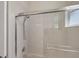 Bathtub with glass sliding doors, shower head, tiled walls, and window at 2871 Royal Palm Dr, North Port, FL 34288