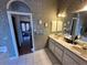 Bathroom with a double vanity sink, a doorway leading to another room, and flamingo artwork on the walls at 316 Orlando Blvd, Port Charlotte, FL 33954