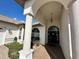 Covered entryway with decorative light fixture and tile, leading to a black front door at 316 Orlando Blvd, Port Charlotte, FL 33954