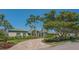Beautiful home exterior with a brick driveway, manicured lawn, and lush, tropical landscaping at 316 W Royal Flamingo Dr, Sarasota, FL 34236