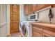 Well-equipped laundry room with washer, dryer, wooden cabinets and folding counter at 316 W Royal Flamingo Dr, Sarasota, FL 34236