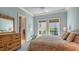 Main bedroom with windows looking onto tropical foliage and en-suite bathroom at 316 W Royal Flamingo Dr, Sarasota, FL 34236