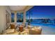 Covered patio with outdoor seating, fireplace, and stunning waterfront views of the pool and bay at 316 W Royal Flamingo Dr, Sarasota, FL 34236
