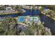 Aerial view of waterfront complex with pool and tennis courts surrounded by lush landscaping at 321 108Th W St # 120, Bradenton, FL 34209