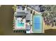 Aerial view of waterfront complex featuring a pool, tennis court, and parking at 321 108Th W St # 120, Bradenton, FL 34209