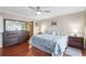 Spacious bedroom featuring hardwood floors, dresser with mirror, and natural light at 321 108Th W St # 120, Bradenton, FL 34209
