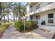 Beautiful condo exterior featuring lush landscaping, mature palm trees, and a convenient entrance at 321 108Th W St # 120, Bradenton, FL 34209