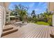 Expansive wooden deck overlooking a lush backyard with tropical landscaping and dining area at 325 12Th W Ave, Palmetto, FL 34221