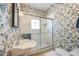 Floral wallpaper in the bathroom adds charm, and the glass-enclosed shower/tub combo features a modern design at 325 12Th W Ave, Palmetto, FL 34221