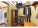Bright walk-in closet featuring custom wood shelves and hanging rods for clothes at 325 12Th W Ave, Palmetto, FL 34221