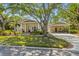 Charming bungalow featuring a well-maintained lawn, beautiful shade tree, and covered carport at 325 12Th W Ave, Palmetto, FL 34221
