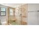 Bathroom featuring a glass shower with dual shower heads, tile flooring, a built-in shelf, and a window at 4104 128Th W St # 704, Cortez, FL 34215