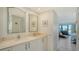 Bright bathroom featuring double vanity with stone countertop and arched mirrors at 4104 128Th W St # 704, Cortez, FL 34215