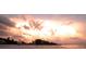 Beachfront view at sunset with striking pink clouds, tranquil waters, and serene beachside dwellings at 4104 128Th W St # 704, Cortez, FL 34215