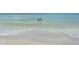 People gather in the ocean waters near a sandy beach shoreline, creating a scene of leisure at 4104 128Th W St # 704, Cortez, FL 34215