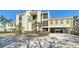 Three story condo with yellow siding, palm trees and covered parking for two cars at 4104 128Th W St # 704, Cortez, FL 34215