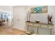 Hallway with wood floors, a turtle wall art, and view into the dining room at 4104 128Th W St # 704, Cortez, FL 34215