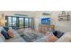 Comfortable living room showcasing light hues, TV, and access to outdoor balcony at 4104 128Th W St # 704, Cortez, FL 34215
