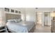 Main bedroom features neutral paint, white floors, a queen bed, and a glimpse into the bathroom at 4104 128Th W St # 704, Cortez, FL 34215