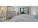 Well-lit main bedroom features a sliding glass door to a private patio, dresser, and closet at 4104 128Th W St # 704, Cortez, FL 34215