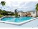 A refreshing community swimming pool with deck chairs and tropical landscaping at 4104 128Th W St # 704, Cortez, FL 34215