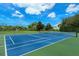 Outdoor tennis court surrounded by lush green landscaping on a sunny day at 4104 128Th W St # 704, Cortez, FL 34215