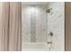 Bathroom featuring shower and bathtub with white tile surround and decorative gray accent tile at 4110 Central Sarasota Pkwy # 123, Sarasota, FL 34238