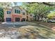 Two-story condo featuring attached garages, colorful stucco, and lush trees at 4110 Central Sarasota Pkwy # 123, Sarasota, FL 34238