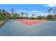 Community tennis court with a view of a pond and surrounding trees at 4110 Central Sarasota Pkwy # 123, Sarasota, FL 34238