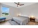 Bright bedroom with a gray quilt, modern ceiling fan, hardwood floors, and side tables with lamps at 4231 Autumn Fog Ct, Palmetto, FL 34221
