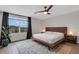A bright main bedroom featuring a modern bedframe, fan and a large window at 4231 Autumn Fog Ct, Palmetto, FL 34221