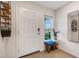 Inviting entryway features a white front door, tile flooring, decor, and natural light from a nearby window at 4231 Autumn Fog Ct, Palmetto, FL 34221